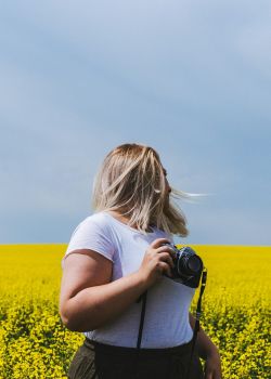 mujer con una cámara en un campo de flores